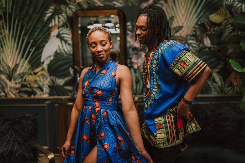 a man and a woman standing next to each other, by Julia Pishtar, pexels contest winner, afrofuturism, wearing a hawaiian dress, épaule devant pose, wakanda, mid-twenties