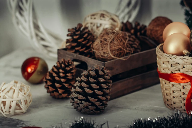 a basket filled with eggs sitting on top of a table, inspired by Ernest William Christmas, trending on pexels, pinecone, wood ornaments, yarn ball, brown colours
