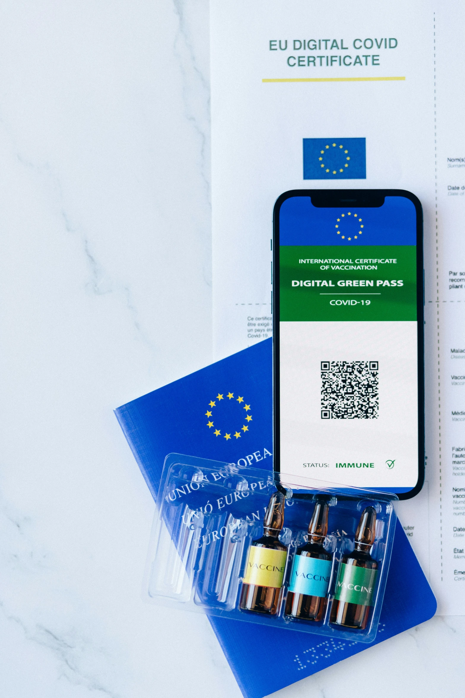 a phone sitting on top of a table next to a passport, by Daniel Lieske, unsplash, pathology sample test tubes, green and blue, european union, with labels. high quality