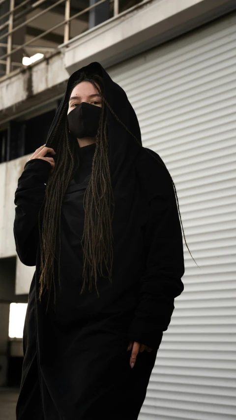 a woman with long hair wearing a black hoodie, inspired by Gang Hui-an, unsplash, white man with black fabric mask, dreadlock black hair, trending on r/streetwear, dark. no text