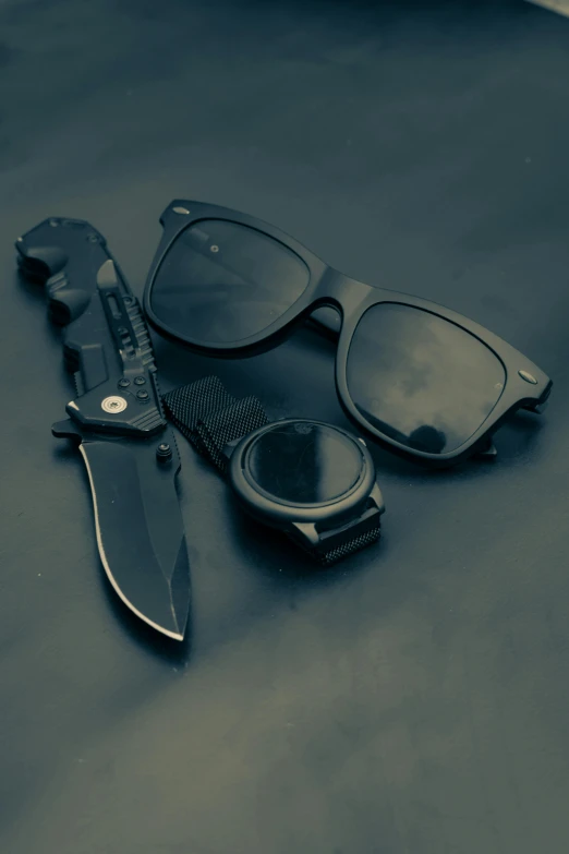 a pair of sunglasses and a knife on a table, trending on r/techwearclothing, profile picture 1024px, black habit, hgrenades