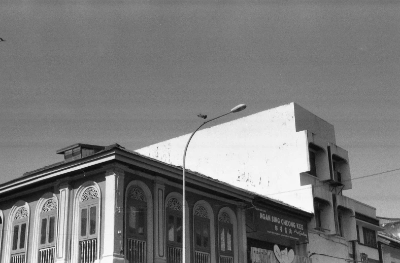 a black and white photo of an old building, by Ismail Acar, flickr, photorealism, blue sky, kuang hong, khedival opera house, taken on a 1990s camera