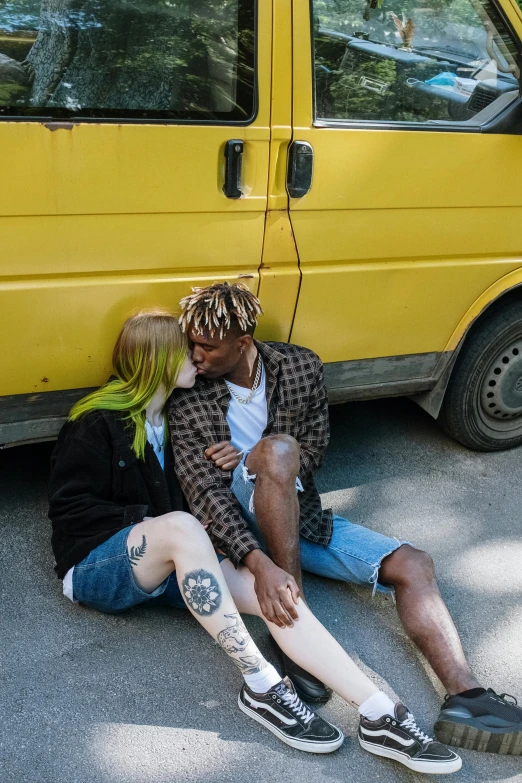 a man and a woman sitting next to a yellow van, inspired by Elsa Bleda, trending on pexels, renaissance, lesbian kiss, black man, yellow hair, split dye