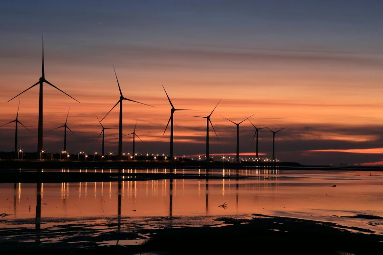 a group of wind turbines sitting on top of a beach, by Jesper Knudsen, pexels contest winner, sunset panorama, fan favorite, floating power cables, nighttime