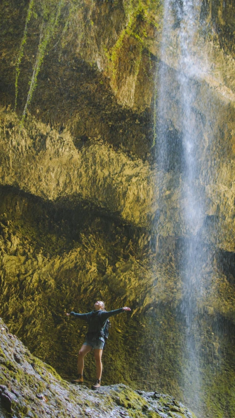 a man standing in front of a waterfall, happening, taking from above, filmstill, stretch, thumbnail