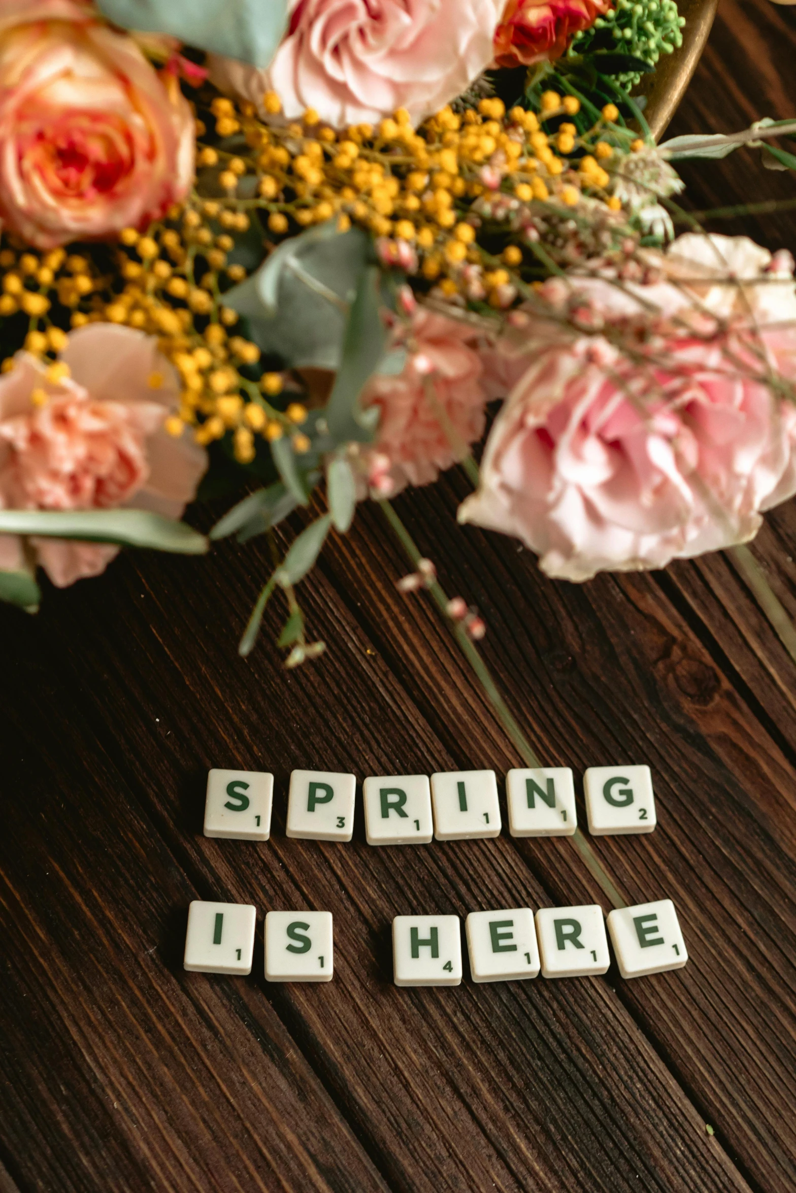 a bouquet of flowers sitting on top of a wooden table, a picture, by Robbie Trevino, trending on unsplash, happening, green letters, early spring, tiles, i'm here