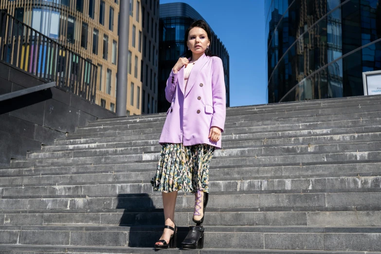 a woman standing on the steps of a building, inspired by Min Zhen, pexels, baroque, wearing a purple frock coat, wearing jacket and skirt, pastel clothing, youtube thumbnail