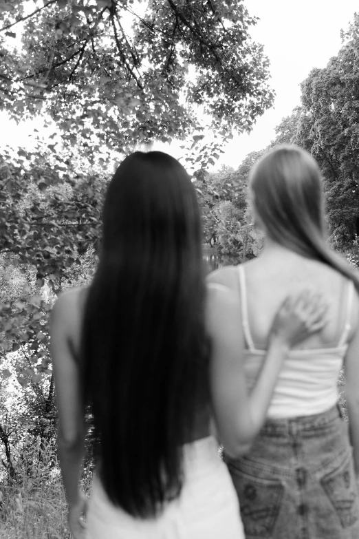 a couple of women standing next to each other, a black and white photo, inspired by Nell Dorr, tumblr, symbolism, light dark long hair. apathetic, her back is to us, taken in the late 2000s, in a jungle