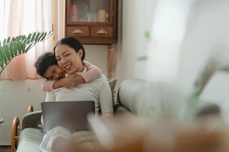 a couple of women sitting on top of a couch, pexels contest winner, hugs, sitting in front of computer, child, asian female