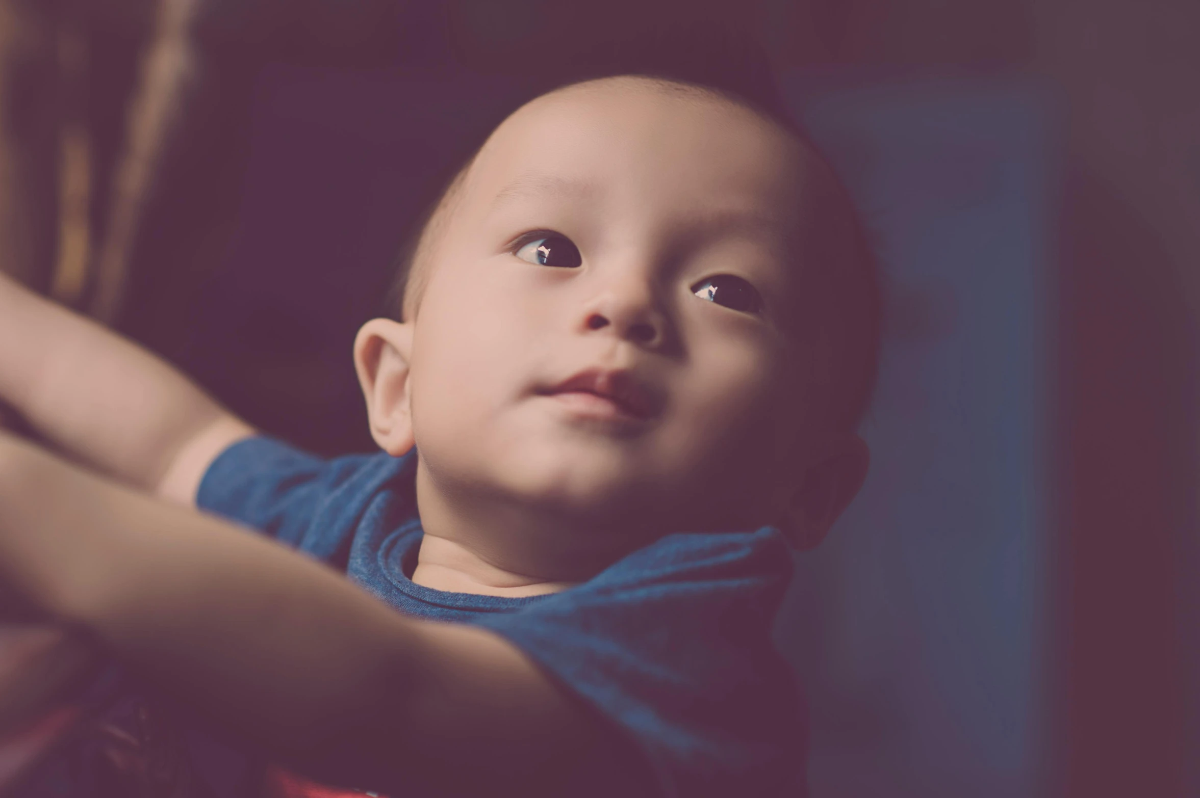 a close up of a child holding a remote control, by Joseph Severn, pexels contest winner, symbolism, young cute wan asian face, looking upwards, under a spotlight, looking to his side