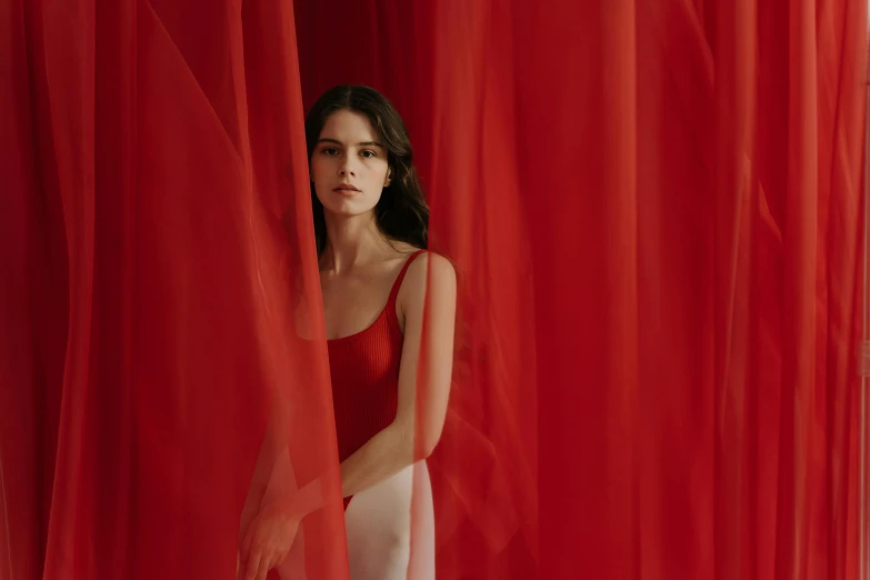 a woman standing in front of a red curtain, inspired by Vanessa Beecroft, pexels contest winner, lana del rey, sheer fabrics, aerial silk, in colour