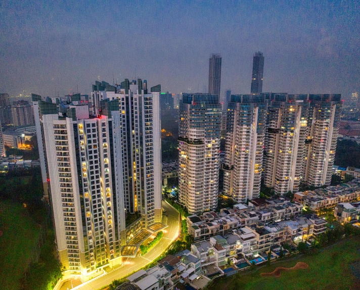 an aerial view of a city at night, by Joseph Severn, pexels contest winner, mumbai in the future, concrete housing, grass field surrounding the city, ten flats