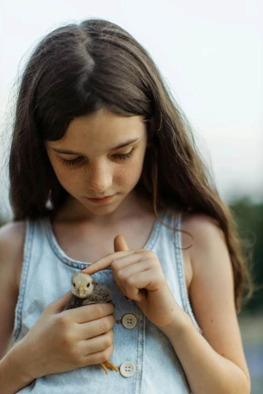 a young girl holding a small bird in her hands, by irakli nadar, pexels contest winner, renaissance, medium format. soft light, snail, denim, 15081959 21121991 01012000 4k