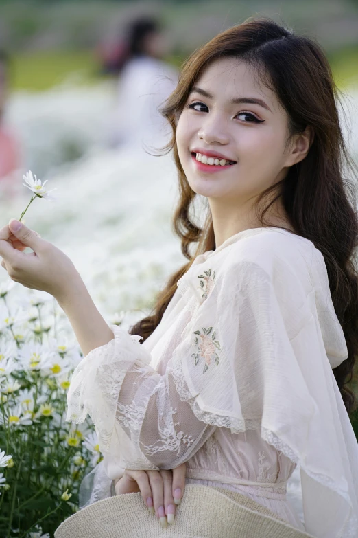 a woman standing in a field of flowers holding a flower, a picture, by Tan Ting-pho, fine art, smiling girl, white lace clothing, dang my linh, medium close-up shot