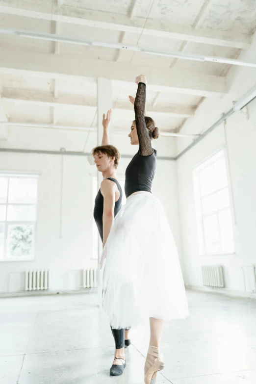 a couple of women standing next to each other in a room, by Elizabeth Polunin, shutterstock, arabesque, white studio, raising an arm, square, wearing a tutu