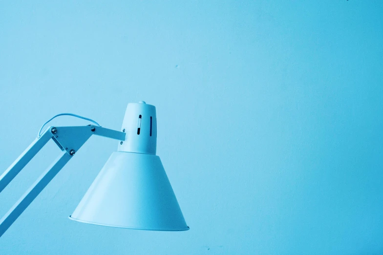 a white lamp sitting on top of a table, an album cover, inspired by Elsa Bleda, unsplash, blue wall, hospital lighting, light-blue, student