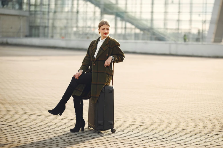 a woman sitting on top of a piece of luggage, over-knee boots, ewa juszkiewicz, black, medium height
