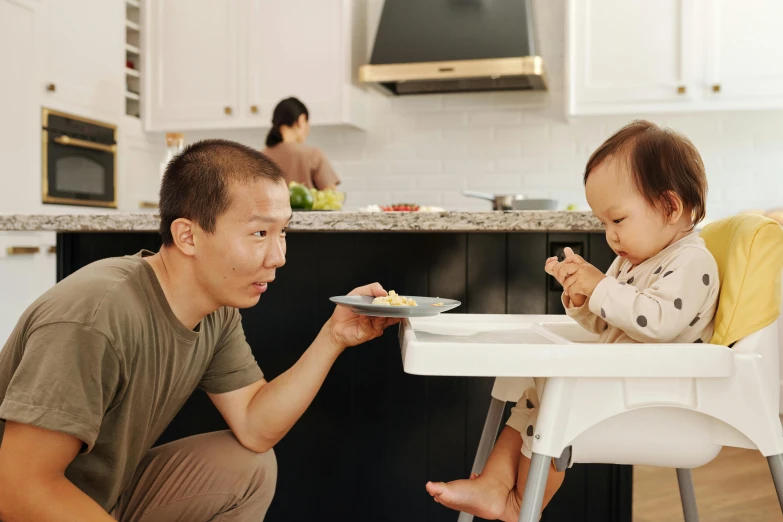 a man feeding a baby in a high chair, pexels contest winner, zeen chin and terada katsuya, avatar image, gemma chan, ikea