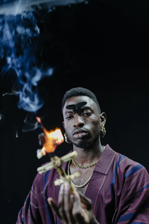 a man with a cigarette in his hand, an album cover, inspired by Godfrey Blow, trending on pexels, hyperrealism, playboi carti, holding a torch, incense, medium head to shoulder shot