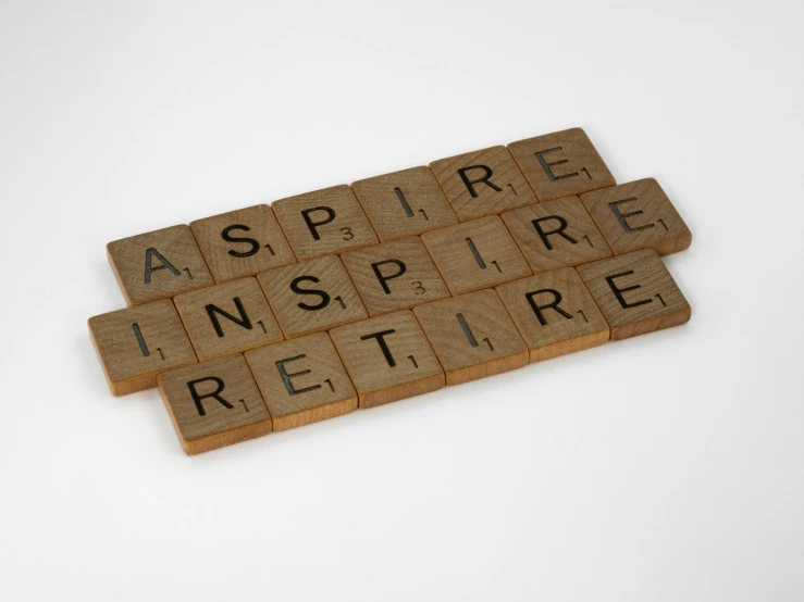 a scrabble board with the word inspire written on it, inspired by Robert Maguire, asset on grey background, each wish resign ’ d, a wooden, troika games
