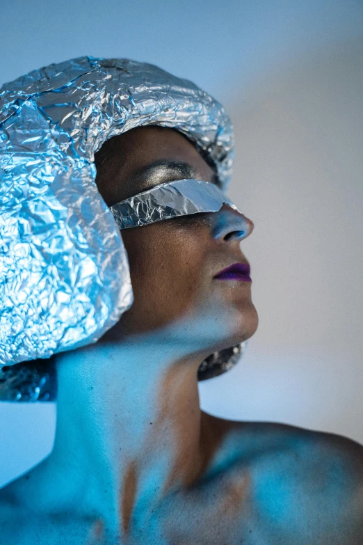 a woman with tin foil on her head, inspired by Cindy Sherman, unsplash, afrofuturism, venus squid astronaut, light show, solarised, non binary model