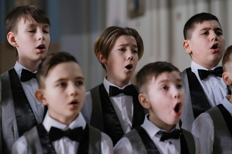 a group of young boys standing next to each other, an album cover, by László Balogh, shutterstock, danube school, singing at a opera house, in church, shot with sony alpha 1 camera, full of expressions