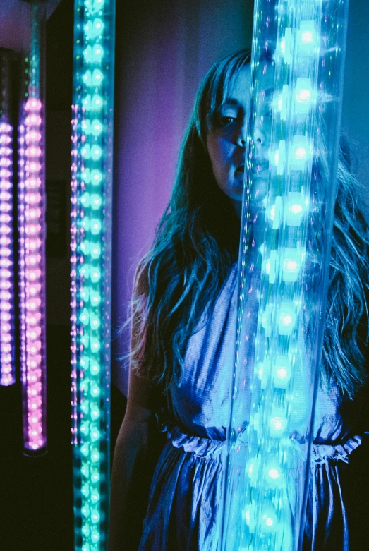 a woman that is standing in front of some lights, inspired by Bruce Munro, pexels, cyan and magenta, crystal column, cinematic pastel lighting, high light on the left