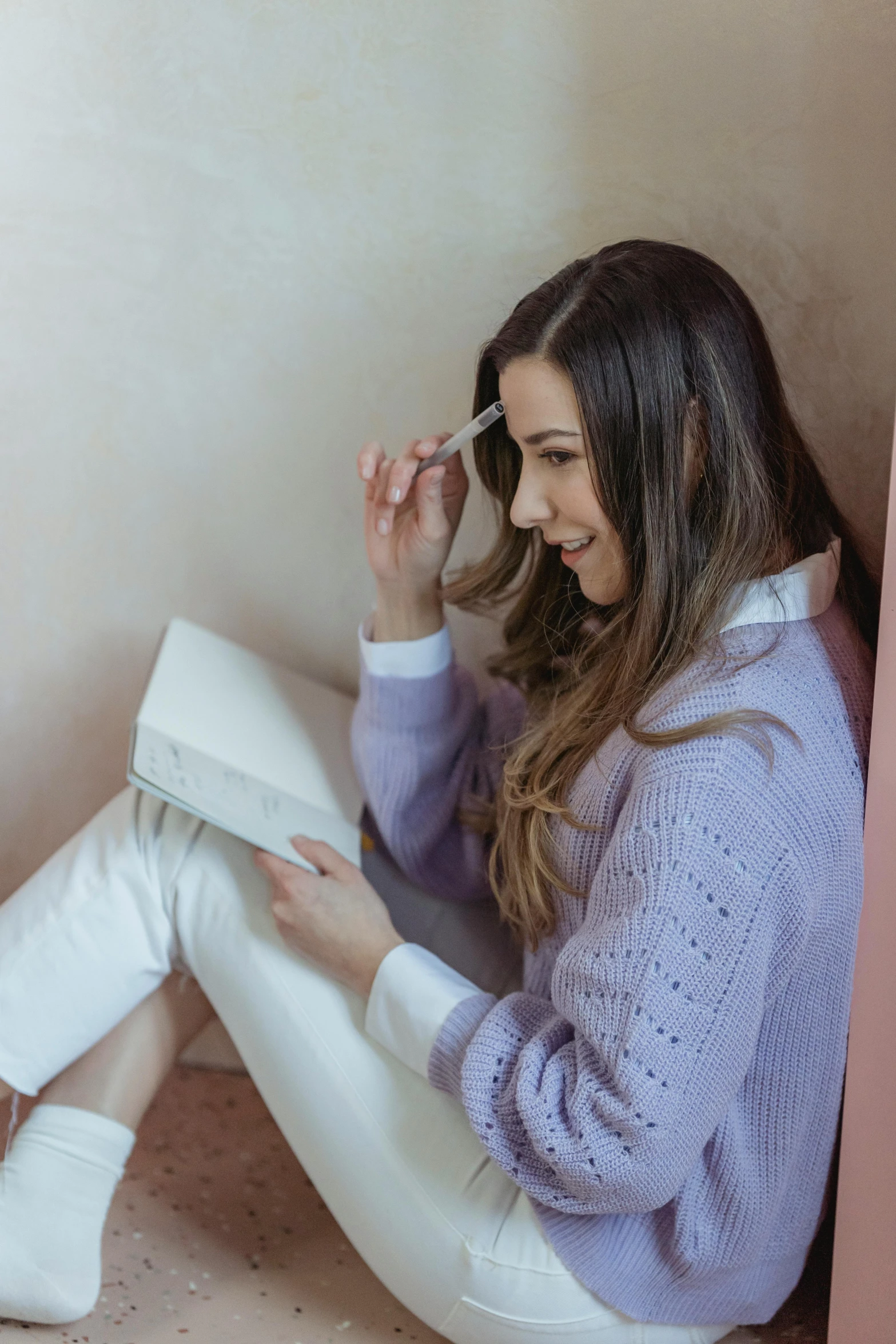 a woman sitting on the floor reading a book, a sketch, trending on pexels, happening, purple outfit, wearing a white sweater, brunette, exiting from a wardrobe