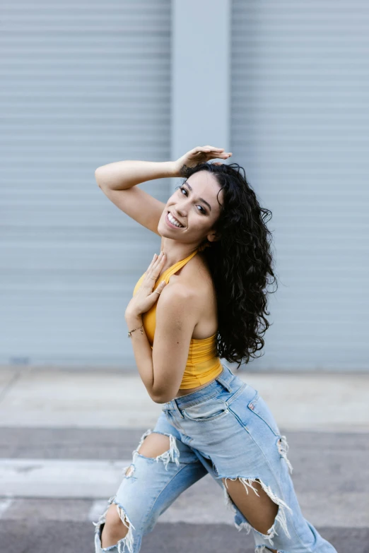 a woman in a yellow tank top and ripped jeans, by Robbie Trevino, trending on pexels, curly black hair, avatar image, vanessa morgan, female dancer