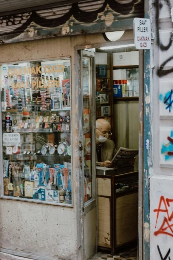 a man that is standing in front of a store, pexels contest winner, graffiti, shelves filled with tomes, smoking a cigarrette🚬, old lady cyborg merchant, istanbul