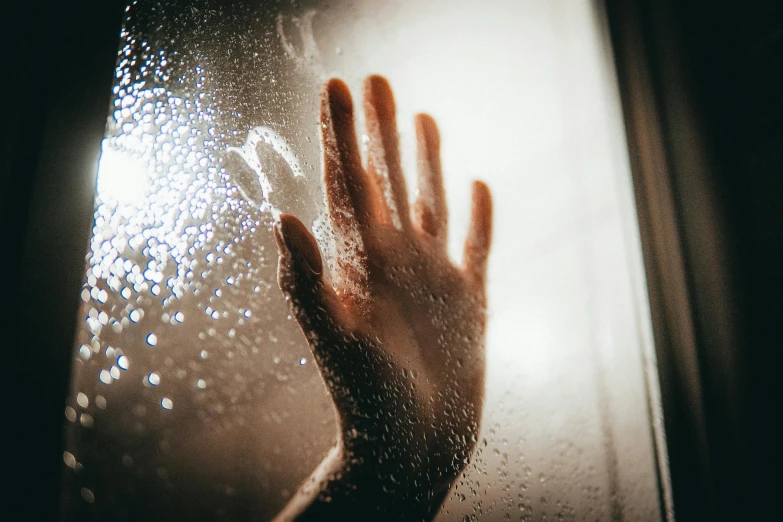 a close up of a person's hand near a window, trending on pexels, drowned, dripping light drops, looking scared, showers