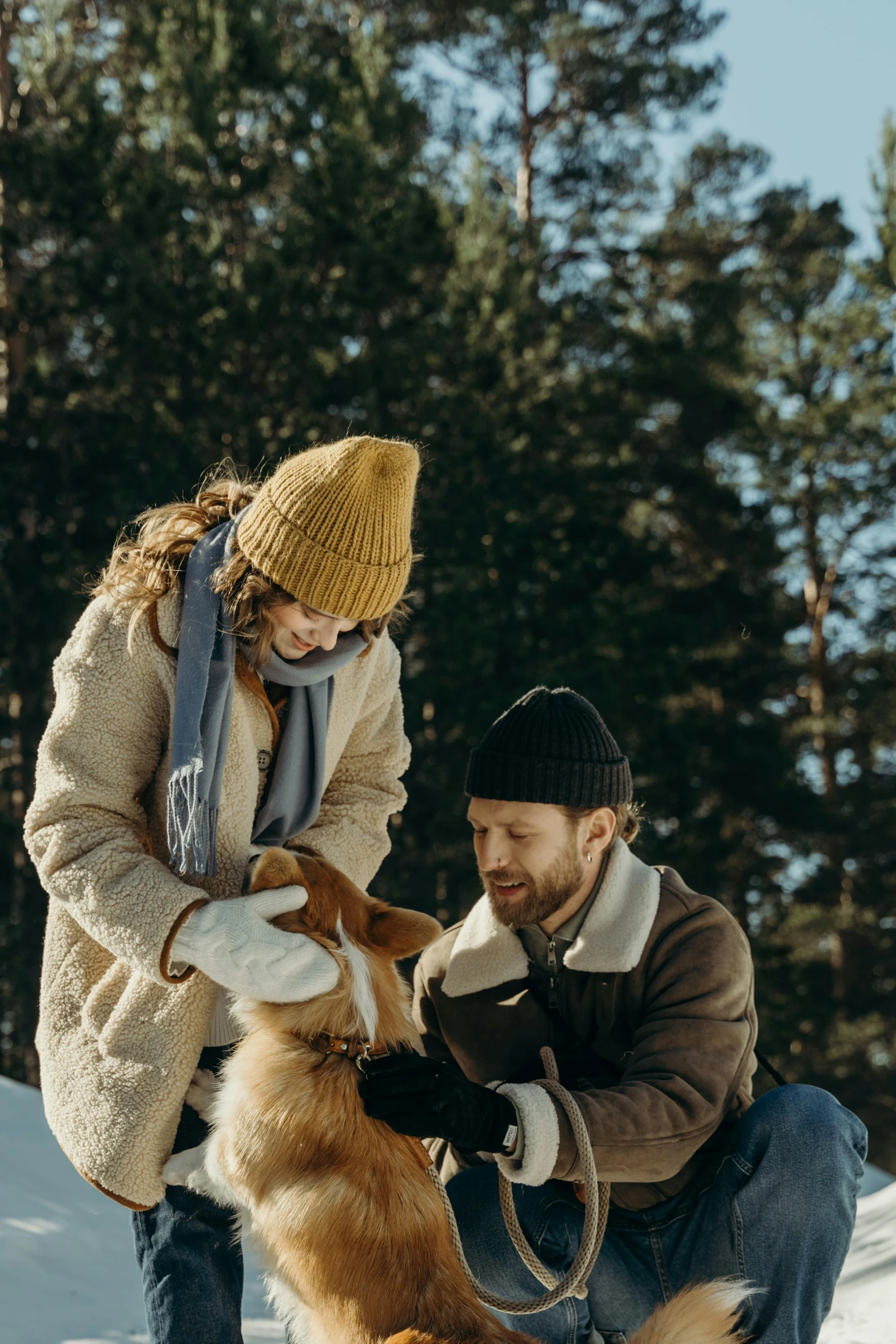 a man and woman playing with a dog in the snow, by Eero Järnefelt, pexels contest winner, renaissance, beanie, tan, movie still, pine