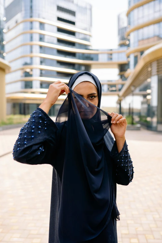 a woman in a hijab poses for a picture, by Julia Pishtar, shutterstock, navy-blue, sheer fabrics, dubai, no face mask