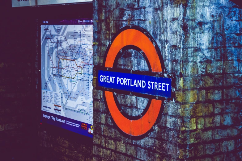 a brick wall with a sign that says great portland street, an album cover, by Julia Pishtar, pexels, london underground tube station, nighttime scene, map, square