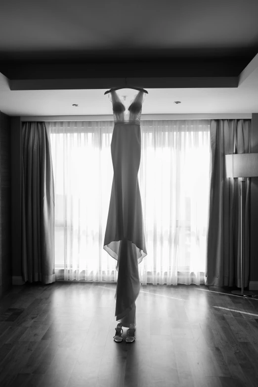 a black and white photo of a dress on a hanger, by Anthony Palumbo, sexy gown, window, jordan matter photography, inside an epic