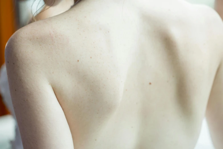 a woman standing in front of a mirror brushing her hair, a tattoo, by Adam Marczyński, trending on pexels, figuration libre, red scales on his back, white freckles, ethereal back light, cracked body full of scars