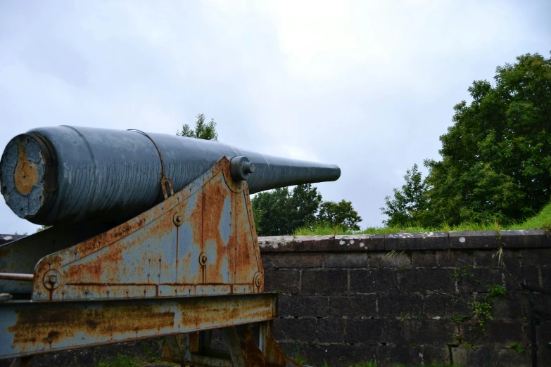 an old cannon sitting on top of a stone wall, an album cover, unsplash, prominent keel-mounted railgun, ventilation shafts, grey metal body, museum photo