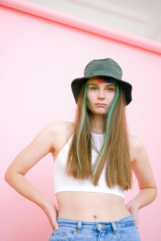 a woman with green hair standing in front of a pink wall, an album cover, inspired by Elsa Bleda, trending on pexels, color field, bucket hat, young with long hair, portrait of white teenage girl, bright colored streaks of hair