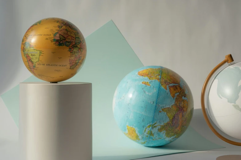 a couple of globes sitting on top of a table, full product shot, multicoloured, middle shot, seen from earth