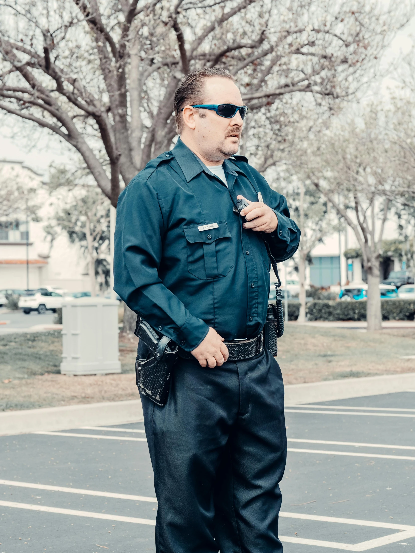 a police officer standing in a parking lot, by Ryan Pancoast, avant designer uniform, oc, profile image, teal uniform