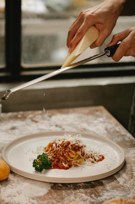 a close up of a plate of food on a table, pouring, pasta, holding a knife, large tall