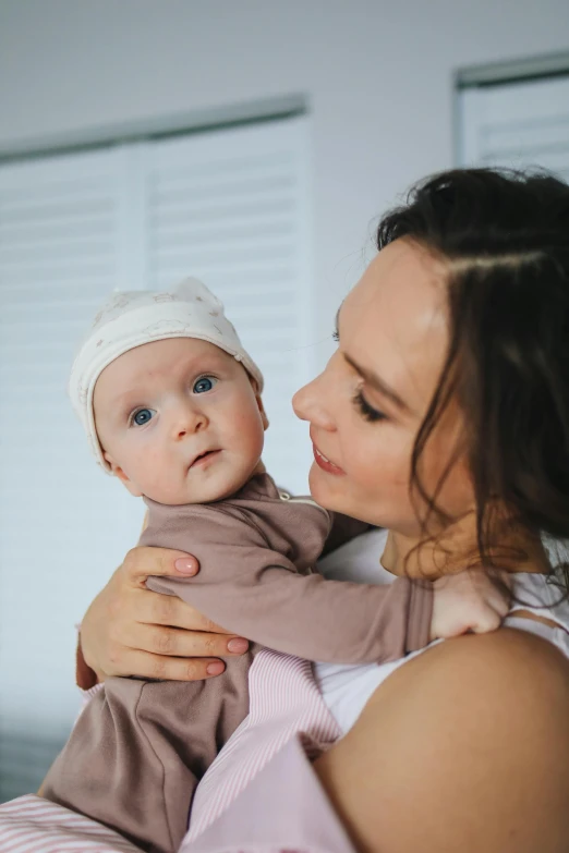 a woman holding a baby in her arms, pexels, portrait of sanna marin, manuka, wrinkly forehead, 15081959 21121991 01012000 4k