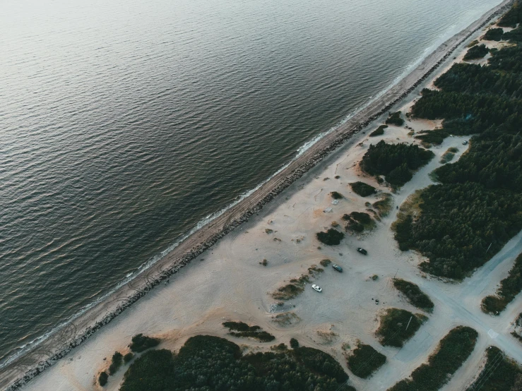 a large body of water next to a sandy beach, by Daniel Lieske, unsplash contest winner, land art, campsites, flying over the horizon, early evening, 2 0 0 0's photo