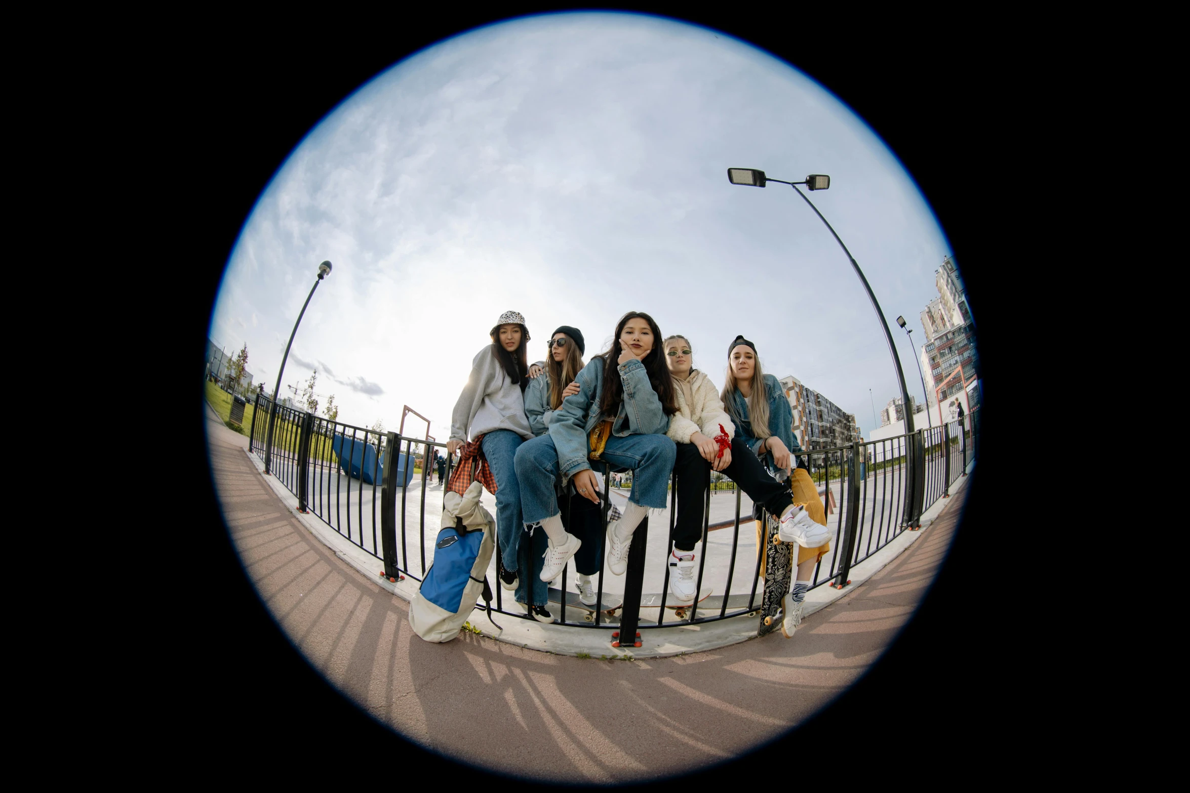 a group of people sitting on top of a skateboard ramp, by Matthias Stom, unsplash, photorealism, ((fish eye)), young girls, looking at us from a porthole, fisheye 4