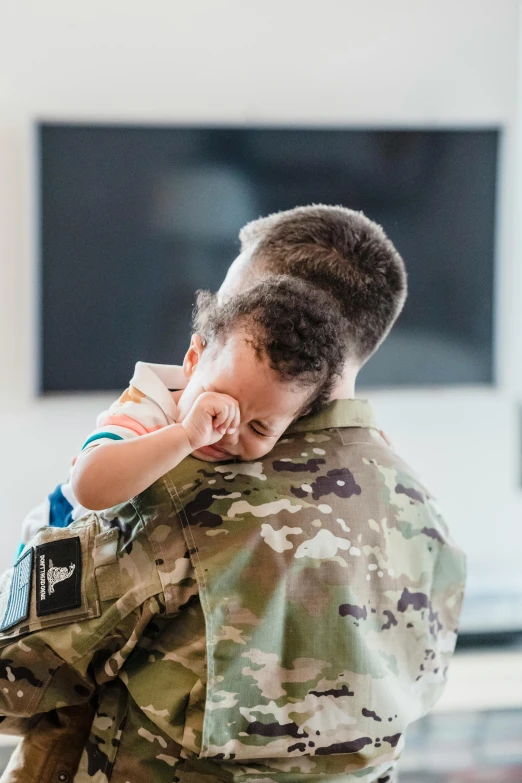 a woman in a military uniform holding a baby, unsplash, hugging each other, boy, healthcare, instagram post