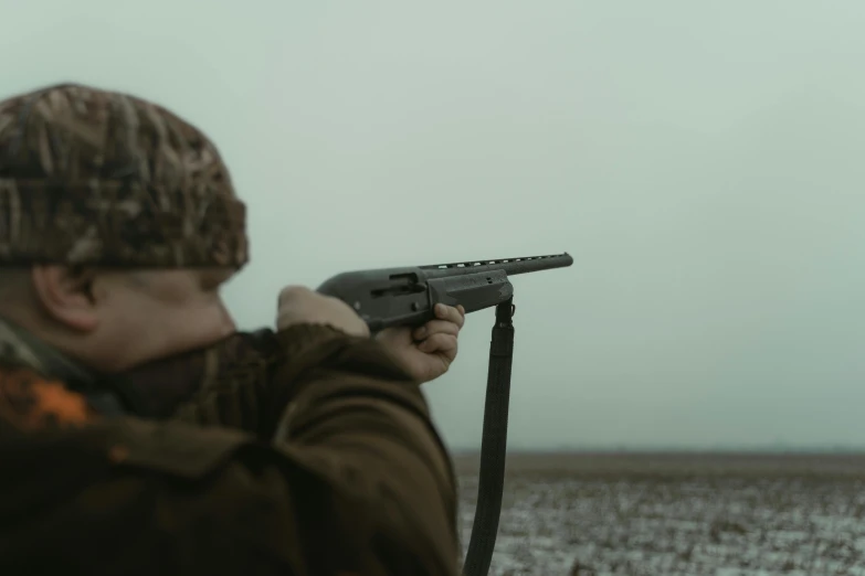 a man that is holding a gun in his hand, by Carey Morris, pexels contest winner, farming, holding shotgun down, low quality photo, cinematic footage