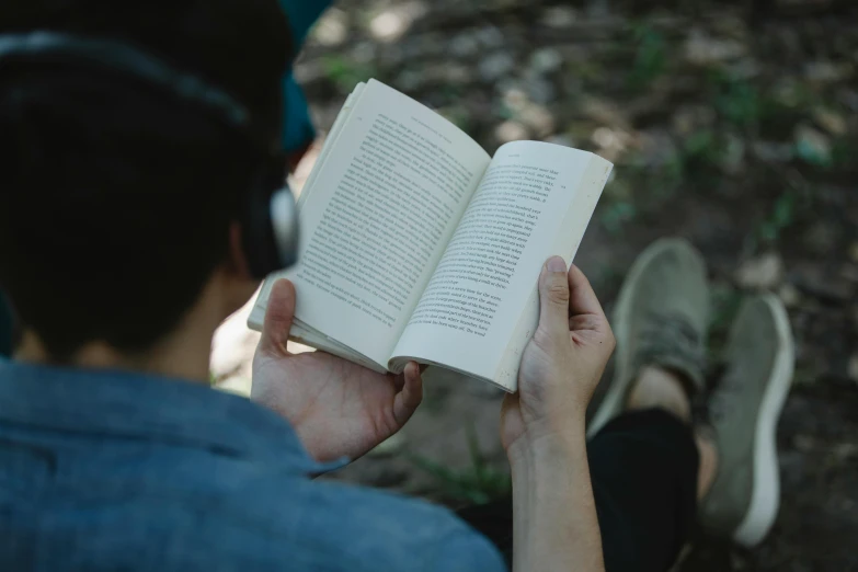 a person reading a book in the woods, pexels contest winner, wearing a headset, without text, background image, [ cinematic