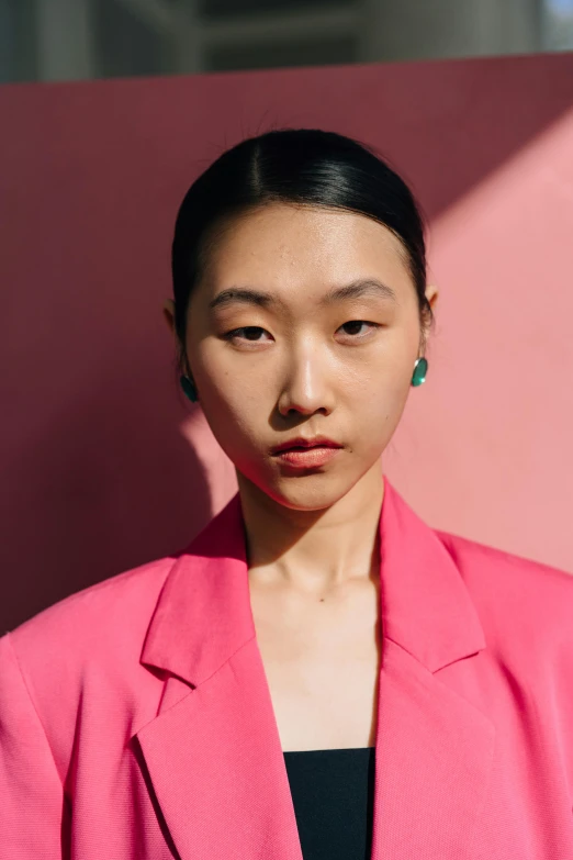 a woman standing in front of a pink wall, inspired by Yanjun Cheng, trending on pexels, hyperrealism, teal suit, jingna zhang, halfbody headshot, evening sun