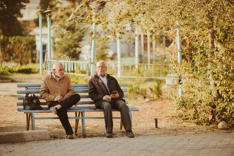 two older men sitting on a park bench, unsplash, brown, alexey egorov, in a square, slightly sunny