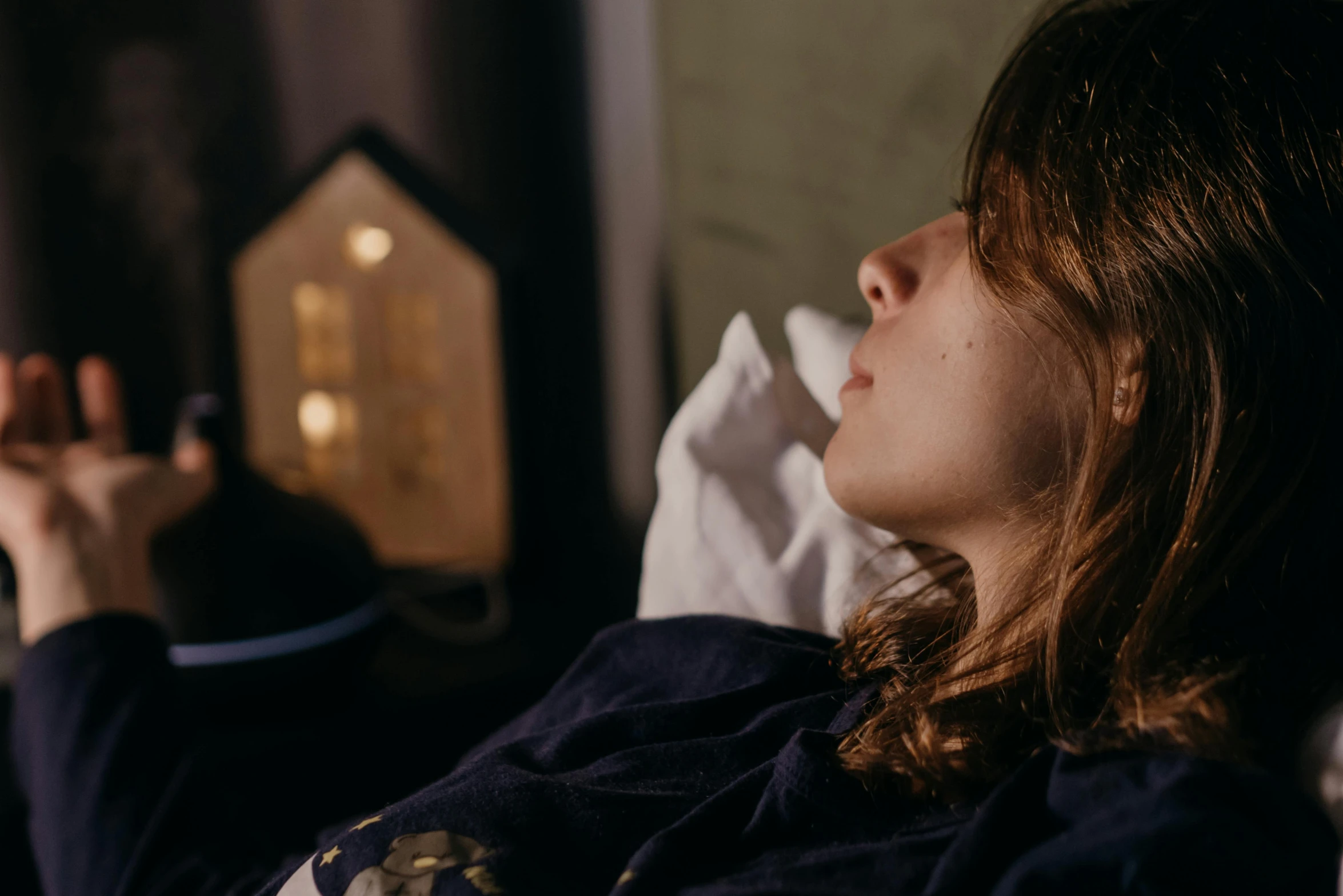 a woman laying in bed with a remote in her hand, trending on pexels, fine art, coughing, side view close up of a gaunt, teenager girl, profile image